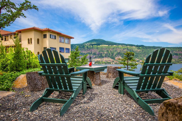 A patio with two chairs and a table with wine