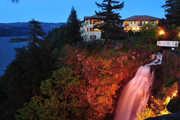 Neighboring waterfall under a stone footbridge at night