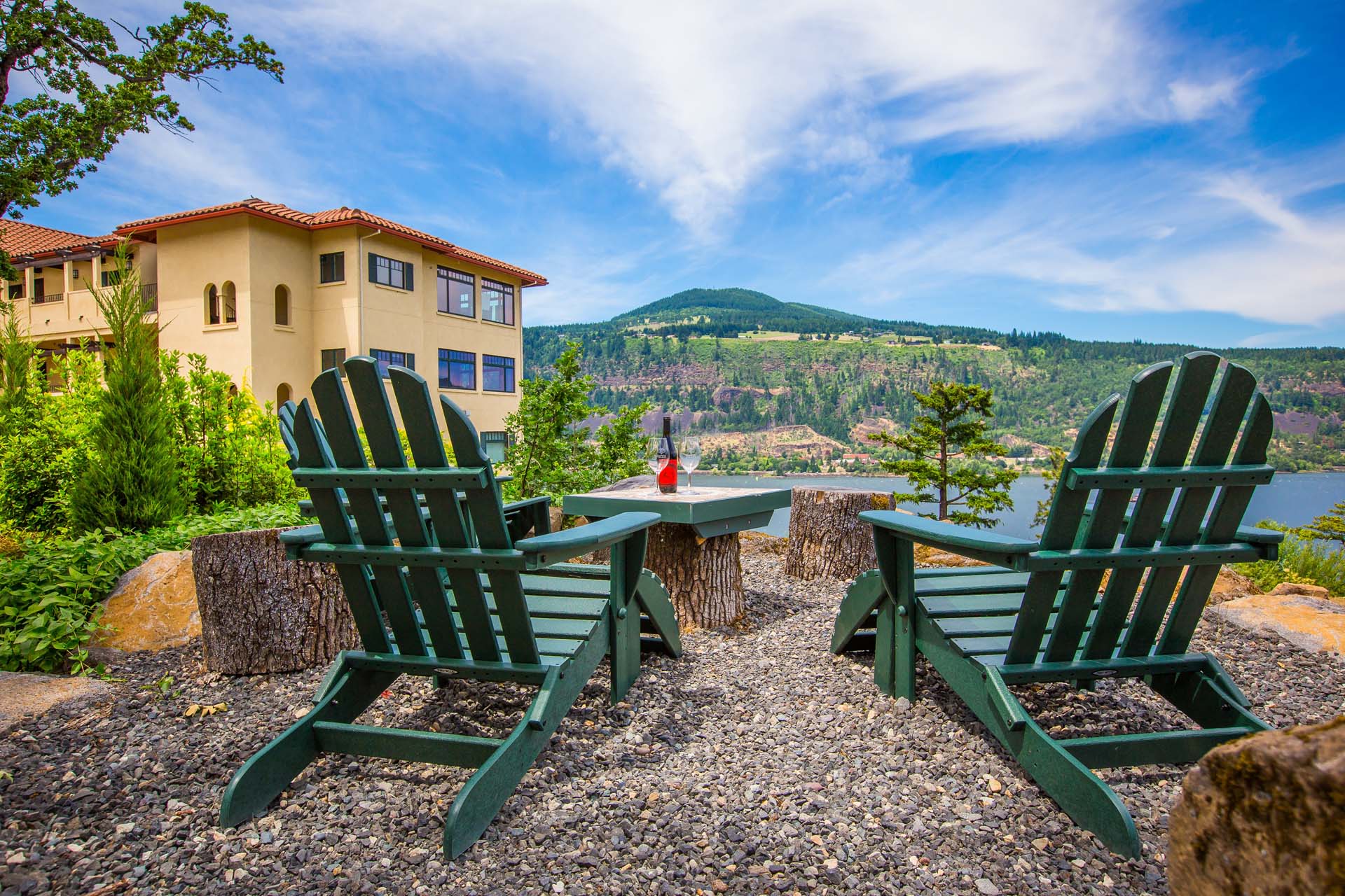 Two outdoor chairs and a table with a wine bottle